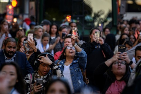 People use their phones to snap pictures of the phenomenon known here as Manhattanhenge

