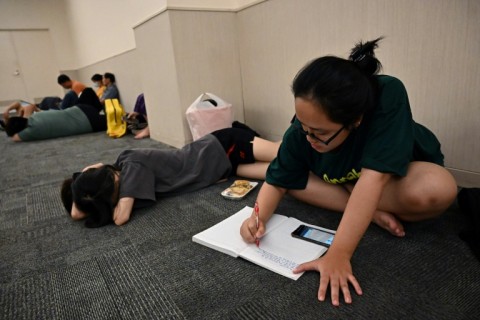 Student Nguyen Minh Thu works on an assignment in a room in a mall set aside for people seeking to escape from high outdoor temperatures