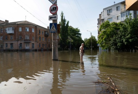 A local resident walks along a flooded street in Kherson