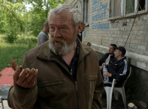 Local resident Sergiy, 68, stands next to a shelter run by volunteers
