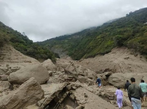 People walk at the site of a landslide in the Quetame municipality in Colombia