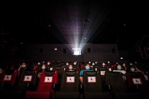 People watching a movie as they sit apart to ensure social distancing on the first day of the reopening of cinemas in China.