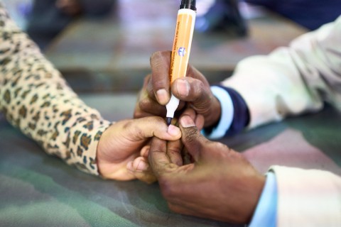 An IEC official marks a voter with indelible ink at a polling station. AFP/Zinyange Auntony