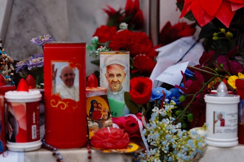 Candles and flowers are laid at the statue of John Paul II at the Gemelli University Hospital where Pope Francis is hospitalised with pneumonia. AFP/Dimitar Dilkoff