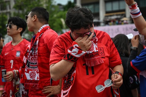 South Korean fans react after their team lost the 2026 World Cup football match against South Africa at Gwanghwamun Square in Seoul on June 25, 2026. (Photo by Jade GAO / AFP)