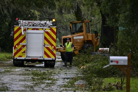 A first responder clears debris off the street in Perry, Florida after Hurricane Idalia slammed into the coast as a powerful Category 3 storm on August 30, 2023