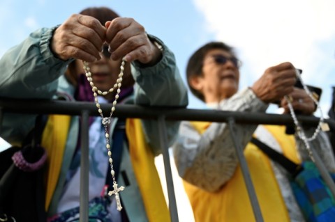 Well-wishers, pray before a welcome ceremony for Pope Francis at Sukhbaatar Square in Ulaanbaatar on September 2, 2023.