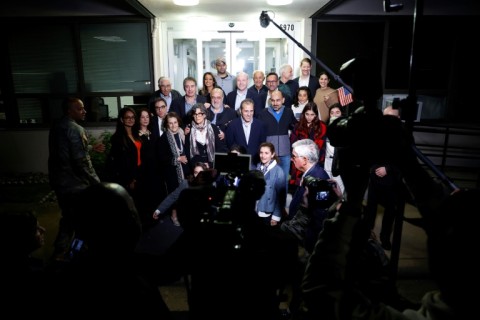 US officials arrange a group photo of the former prisoners freed by Iran landed at an airfield near Washington 