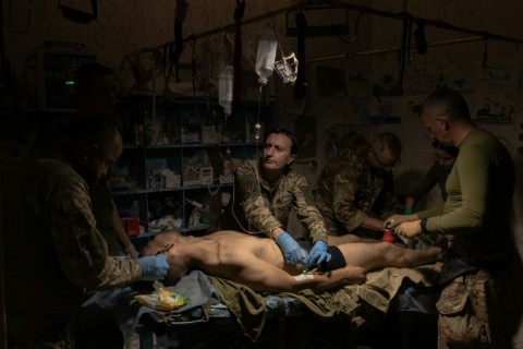 A wounded Ukrainian soldier is treated by Ukrainian military medics in a stabilization point in an undisclosed location near Bakhmut in eastern Ukraine