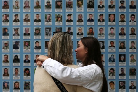 Visitors at the Memory Wall of Fallen Defenders of Ukraine in Kyiv on Sunday