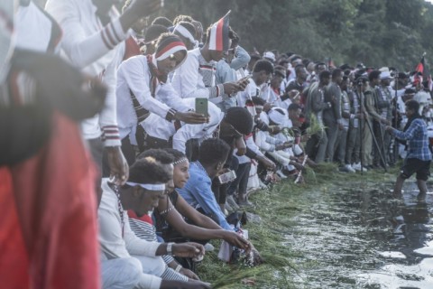 To mark the passage of seasons, old and young at Irreecha dip flowers into the lake and sprinkle themselves with the blessed water
