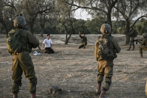 Israeli soldiers detain a man while on patrol near Kibbutz Beeri 