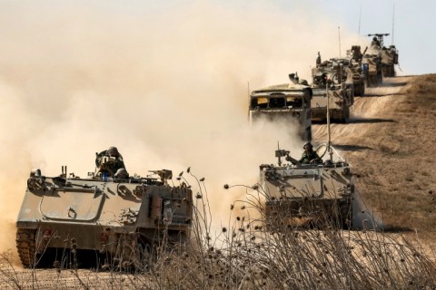 Israeli army infantry fighting vehicles deploy along the border with the Gaza Strip in southern Israel, ahead of an expected ground offensive in the Palestinian territory