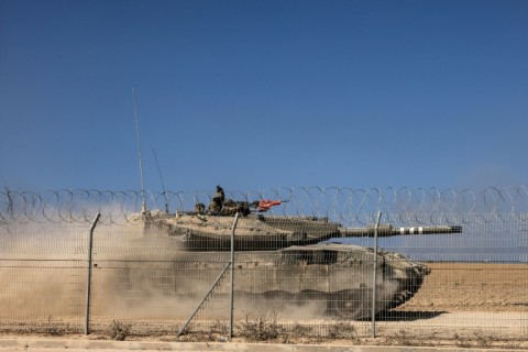An Israeli Merkava tank drives past a fence near Kibbutz Beeri, close to the border with Gaza on October 20, 2023, in the aftermath of an attack by Palestinian militants on October 7