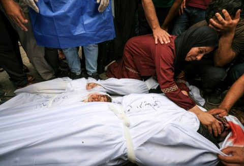 Relatives of a Gaza family killed following an Israeli strike mourn the dead prior to their burial, in Khan Yunis on October 23, 2023