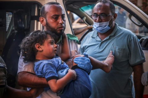 A wounded Palestinian child is carried into the Nasser hospital following Israeli bombardment in Khan Yunis, in the southern Gaza Strip on October 26, 2023