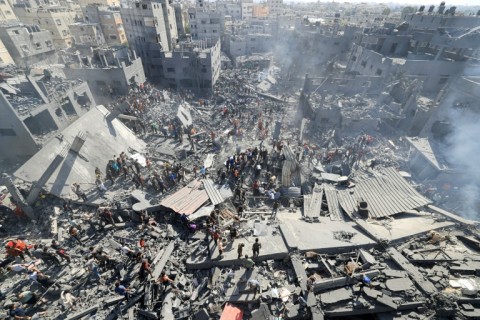 People search for survivors and the bodies of victims in the rubble of buildings destroyed during Israeli bombardment, in Khan Yunis in the southern Gaza Strip on October 26, 2023