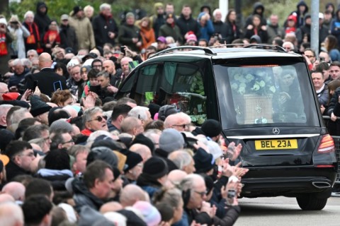 A hearse carrying the coffin of Bobby Charlton is driven past Old Trafford 