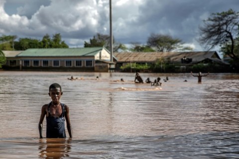 Children play and swim in an inundated football pitch in Garissa 