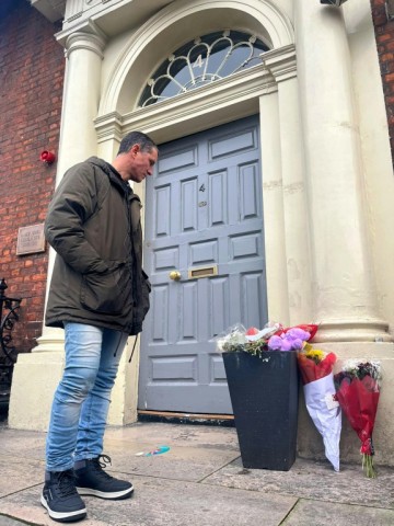 Brazilian Caio Benicio looks at flowers placed at the scene of the November 23 attack in Dublin