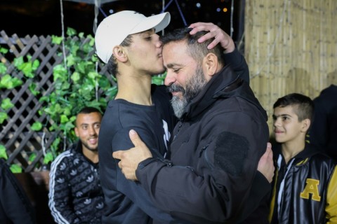 Palestinian Mohammed al-Awar (L), a former prisoner released from an Israeli jail in exchange for hostages freed by Hamas in Gaza, kisses his father's forehead upon return to his home in east Jerusalem