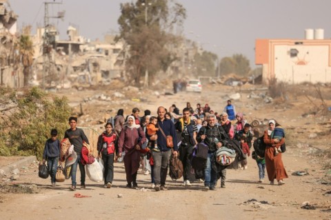 Palestinians fleeing the north walk along Salaheddine road in Zeitoun district on the outskirts of Gaza City