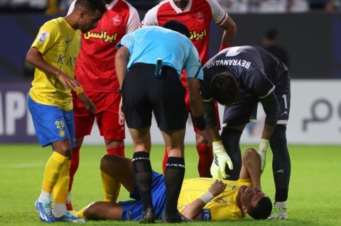 Cristiano Ronaldo holds his neck in pain after a collision with Persepolis goalkeeper Alireza Beiranvand