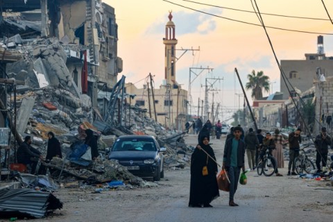 People walk along a street in the Khezaa district on the outskirts of the southern Gaza Strip city of Khan Yunis