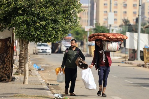 Residents of the Qatari-funded Hamad Town residential complex in Khan Yunis flee with their belongings after receiving notification from the Israeli army of an imminent strike