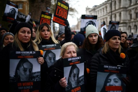 Demonstrators hold posters reading 'UN Women, your silence is loud' alongside pictures of Israeli women being held hostage in Gaza, during a rally in London on December 3, 2023 