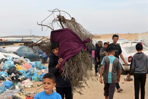 A boy carries wood for heating and cooking in Rafah, the southern Gaza Strip, where fuel and other essential supplies are scarce