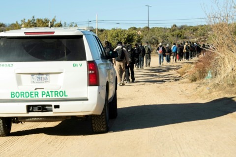 Border patrol agents take migrants who entered the US illegally the day before through the border wall to a port of entry in Jacumba