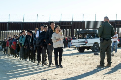 Border patrol agents count migrants who entered the US illegally the day before through the border wall before taking them to a port of entry in Jacumba, California, December 6, 2023