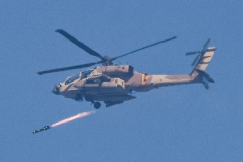 An Israeli air force attack helicopter fires a missile while flying in an area along the border with the Gaza Strip and southern Israel on December 12, 2023 