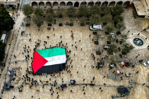 A giant Palestinian flag is unfurled outside the Church of the Nativity in 
the biblical city of Bethlehem in the occupied West Bank on Christmas Eve