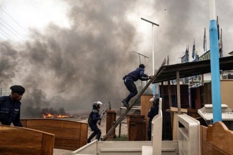 Police officers during clashes with opposition supporters in Kinshasa after a protest march was banned