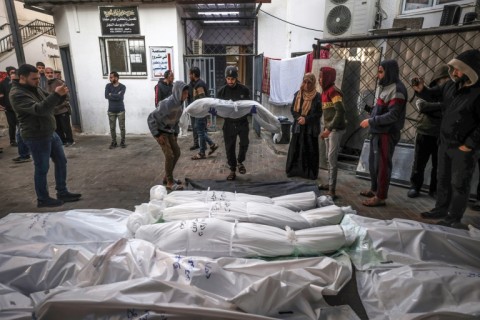 The shrouded bodies of people killed in Rafah during Israeli bombardment on the southern Gaza Strip are placed outside Al-Najar hospital on December 29, 2023