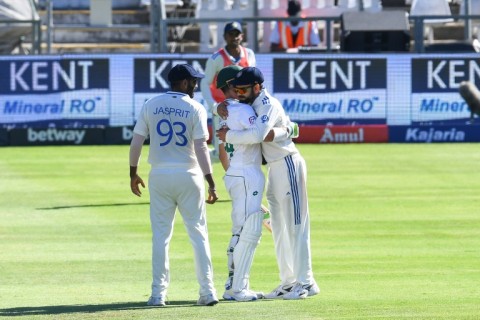Virat Kohli (R) hugs Dean Elgar (C) after the South African captain's dismissal in his final Test innings