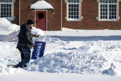 Supporters of former US president and 2024 presidential hopeful Donald Trump carry placards as they brave frigid, sub-zero temperatures to attend a rally in Indianola, Iowa, on January 14, 2024