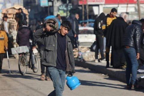 A boy carries gas canisters in Rafah in the southern Gaza Strip