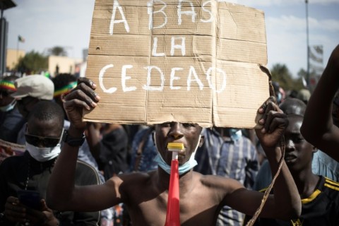 A demonstrator protesting against sanctions on Mali's junta holds a sign reading 'Down with ECOWAS' on January 28, 2024
