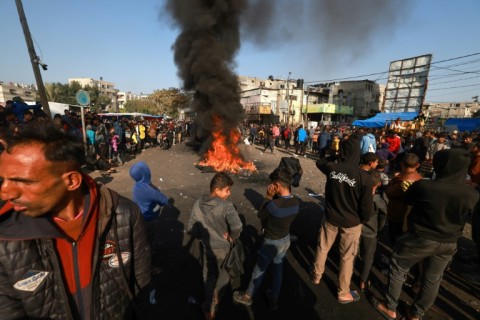 Men carry the bodies of people killed when Israeli forces opened fire on crowds rushing at an aid distribution point in Gaza City on February 29