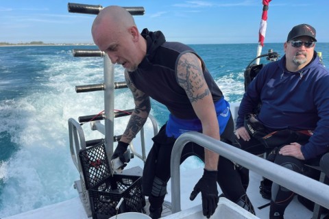 Shark diving guide Jonathan Campbell prepares bait known as chum to be submerged in the water off Florida's coast in order to attract sharks