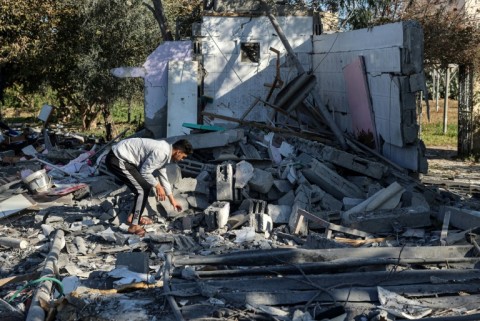 A Palestinian searches for his belongings amid the rubble of houses destroyed by Israeli bombardment in Rafah
