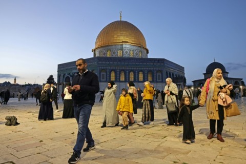 People walk past the Dome of the Rock at the compound of the Al-Aqsa mosque ahead of the start of Islamic holy fasting month of Ramadan, in the Old City of Jerusalem on March 10, 2024
