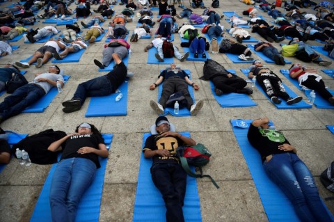 Lying in the heat on synthetic carpets, participants tuned out the chaos of the capital as part of what organizers described as "a peaceful demonstration for the right to sleep"