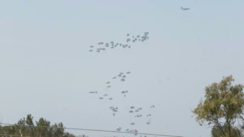 Planes drop aid over the northern Gaza Strip, as seen from the Israeli border