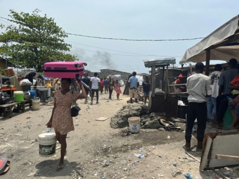 Residents carry their belongings after the demolitions 