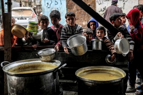 Children in Rafah queue for food ahead of their iftar meal to break the daily fast during Ramadan