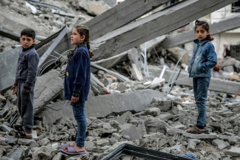 Palestinian children look at the rubble of a building destroyed in an Israeli strike on Gaza City